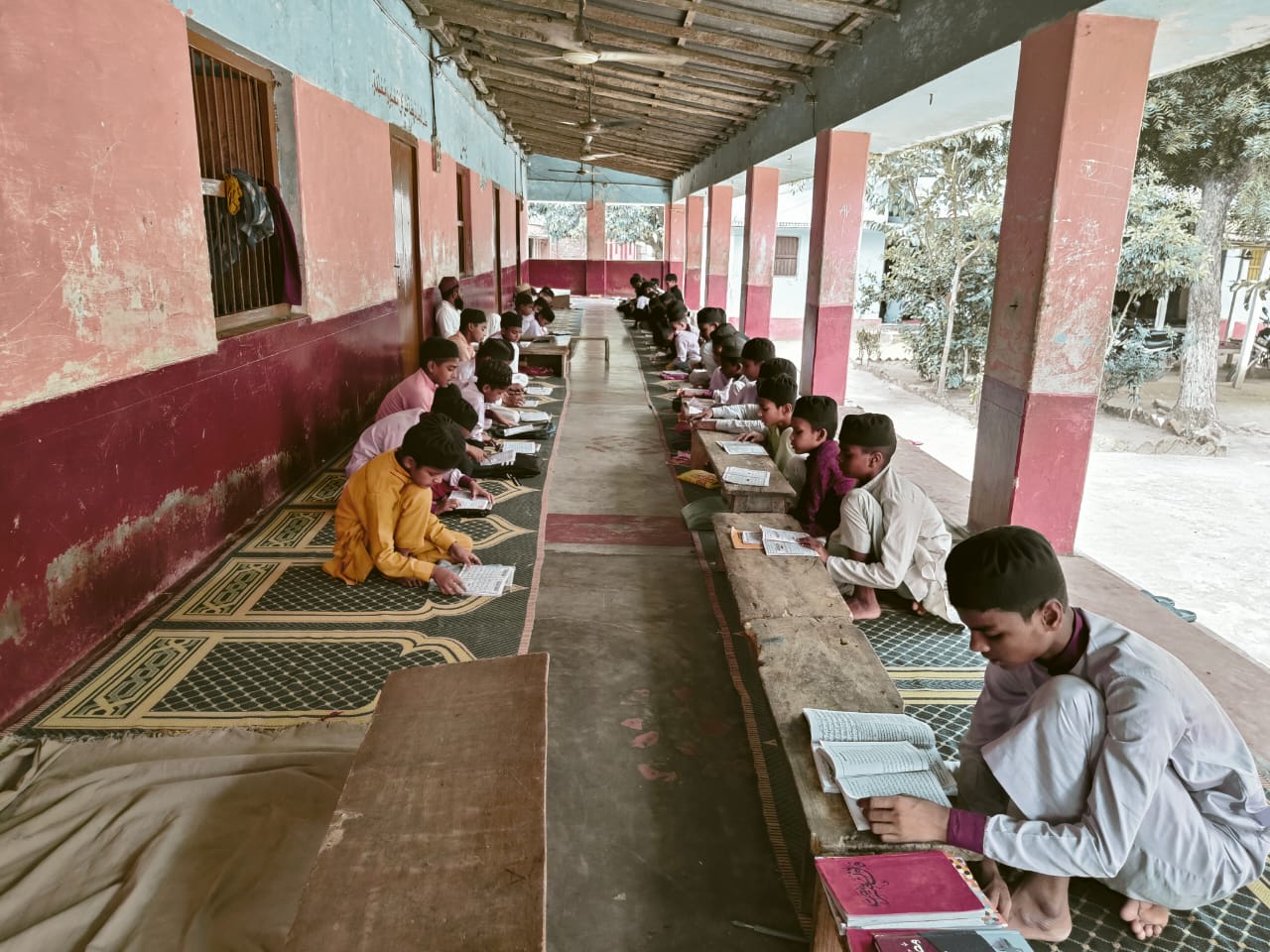 Main entrance of Jamia Usmania college with welcoming arch and students walking