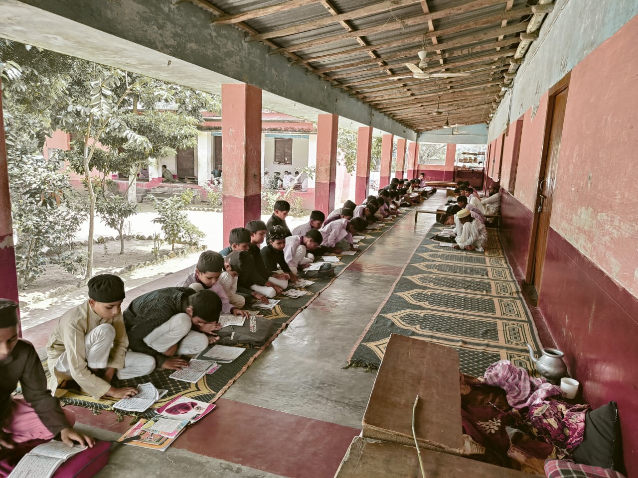 Group of Jamia Usmania students studying together outdoors on campus lawn